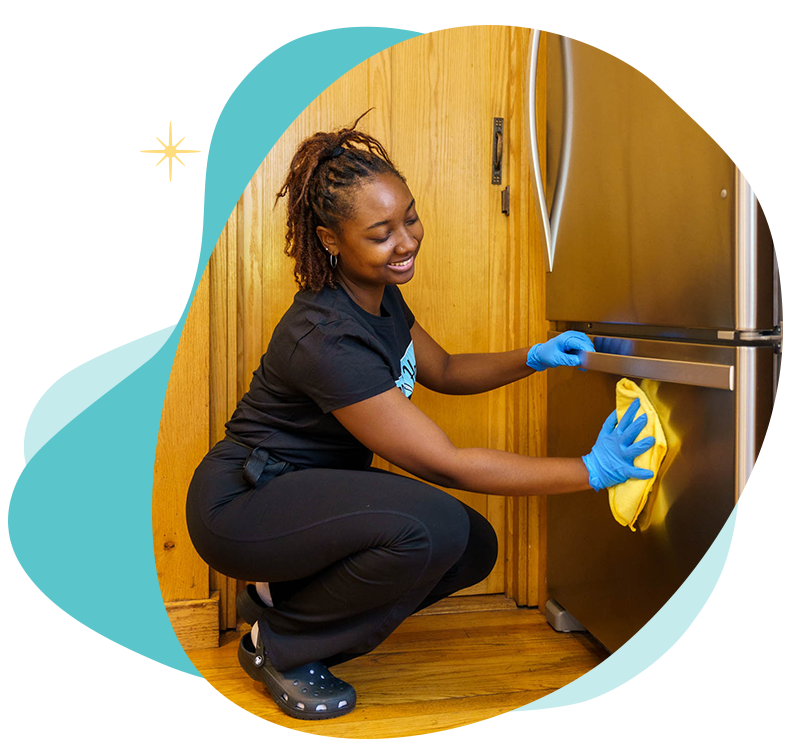 Belle Home cleaner wiping down a refrigerator
